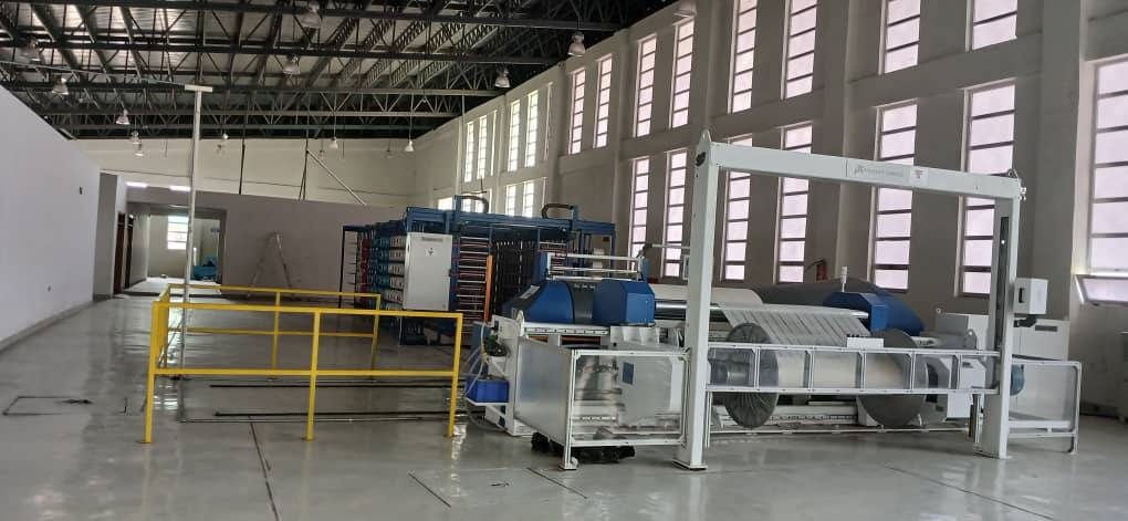 Sectional warping machine on a textile factory floor